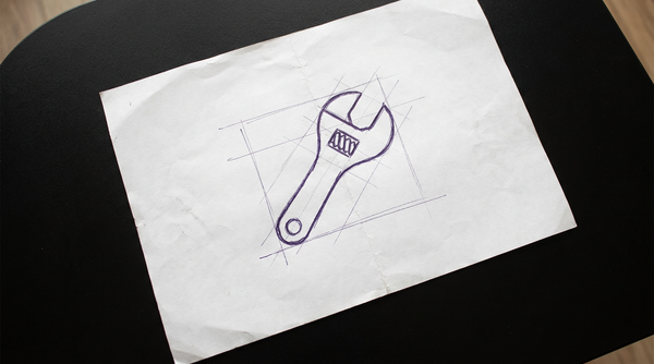 an adjustable wrench, also known as a crescent wrench, with a movable jaw controlled by a worm screw, shown in a partially open position
