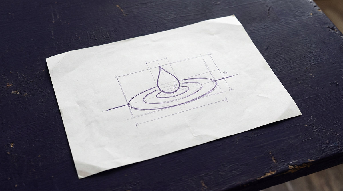 a single liquid droplet, viewed from the side, as it makes contact with a flat, horizontal surface, creating small, concentric ripples emanating outwards from the point of impact
