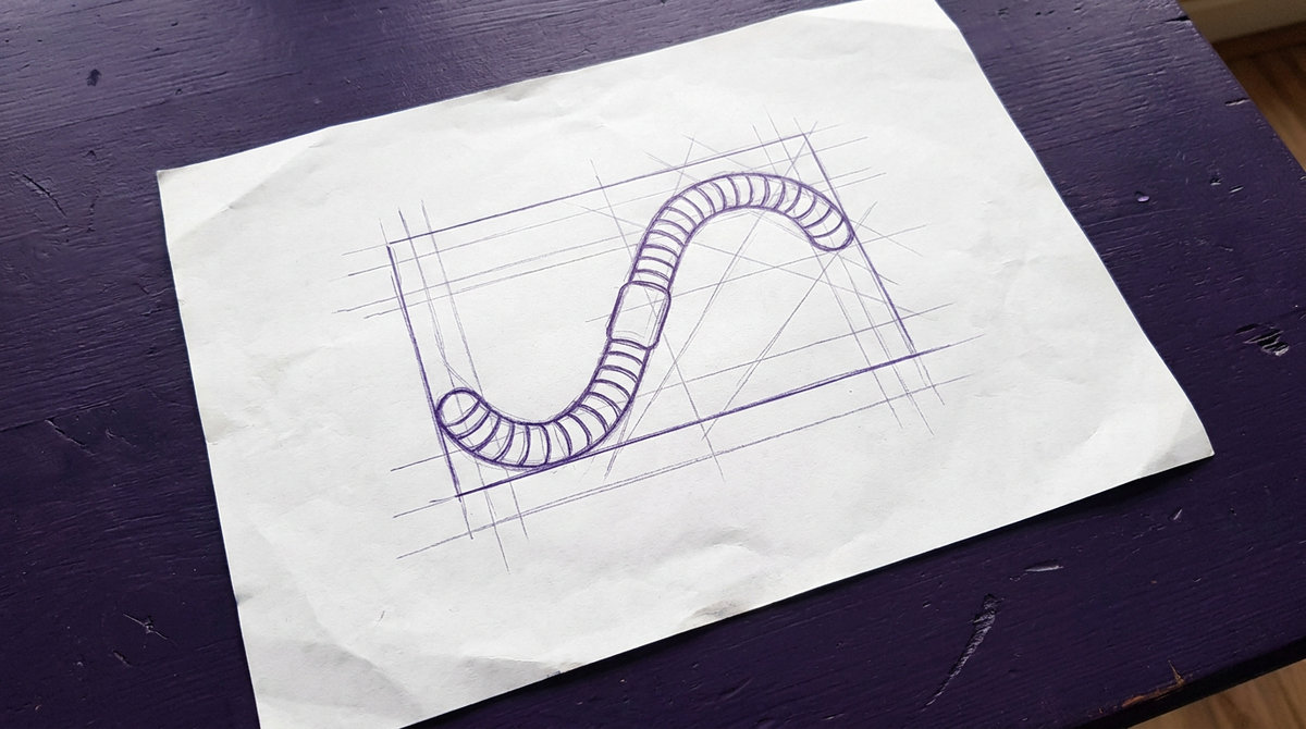 an earthworm with a slender segmented cylindrical body curved in a gentle s-shape with visible ring-like annuli along its length