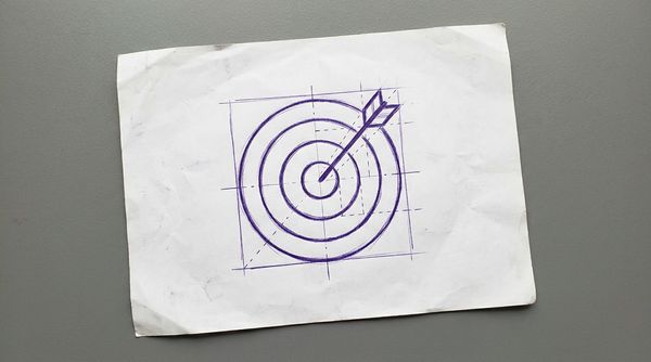 a circular archery target, viewed from the front, with an arrow striking the center bullseye