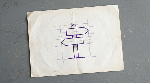a wooden directional signpost with two perpendicular arrow-shaped signs pointing in opposite horizontal directions
