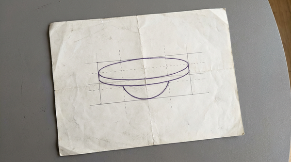 a circular wobble board with a flat top platform and a domed base