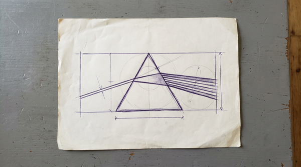 a triangular glass prism, shown dispersing a single beam of white light into a rainbow spectrum